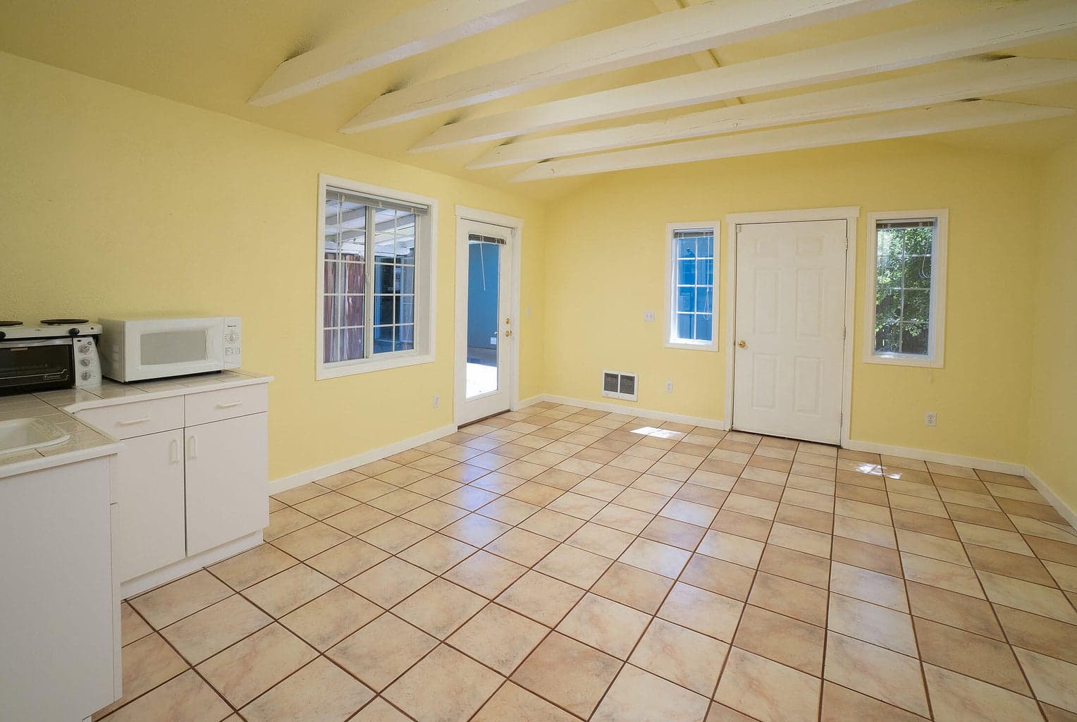 Studio guest cottage features tile flooring, open beams, light and bright! This would also be perfect for a particular hobby such as quilting or sewing.