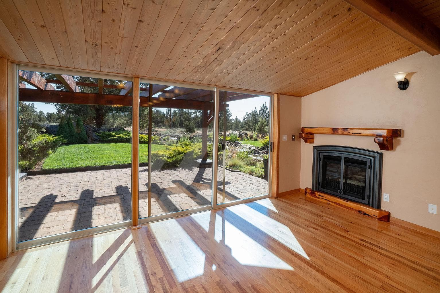 Sun room with darling fireplace, juniper mantel, peaceful backyard stream and patio