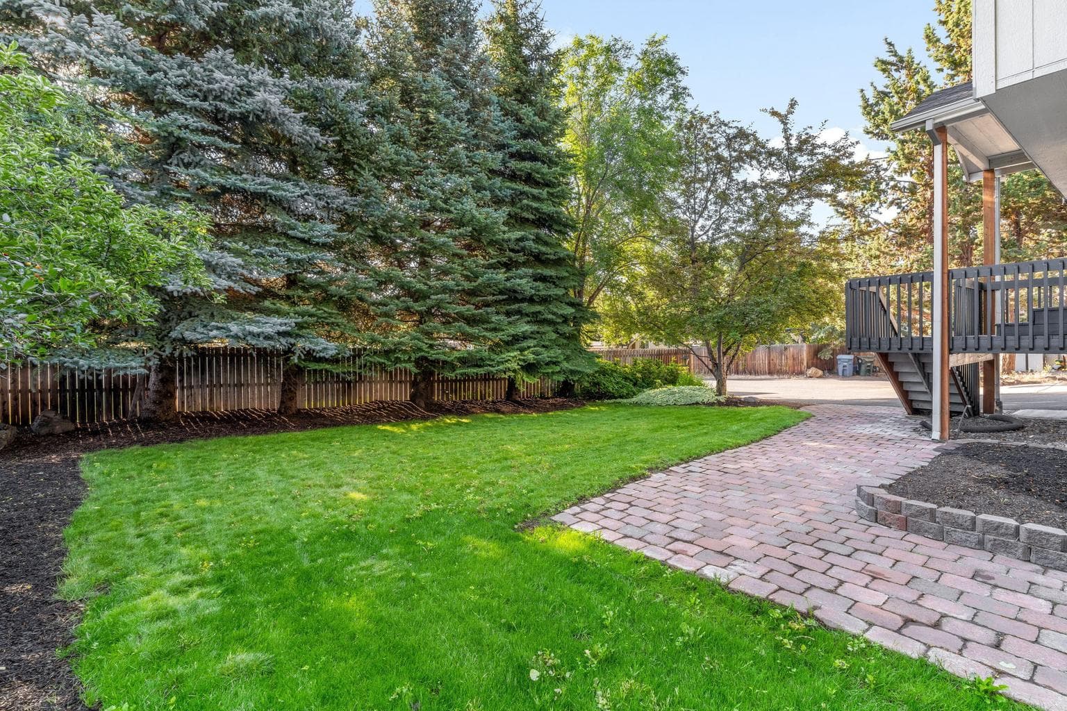 Mature evergreens provide privacy in front.