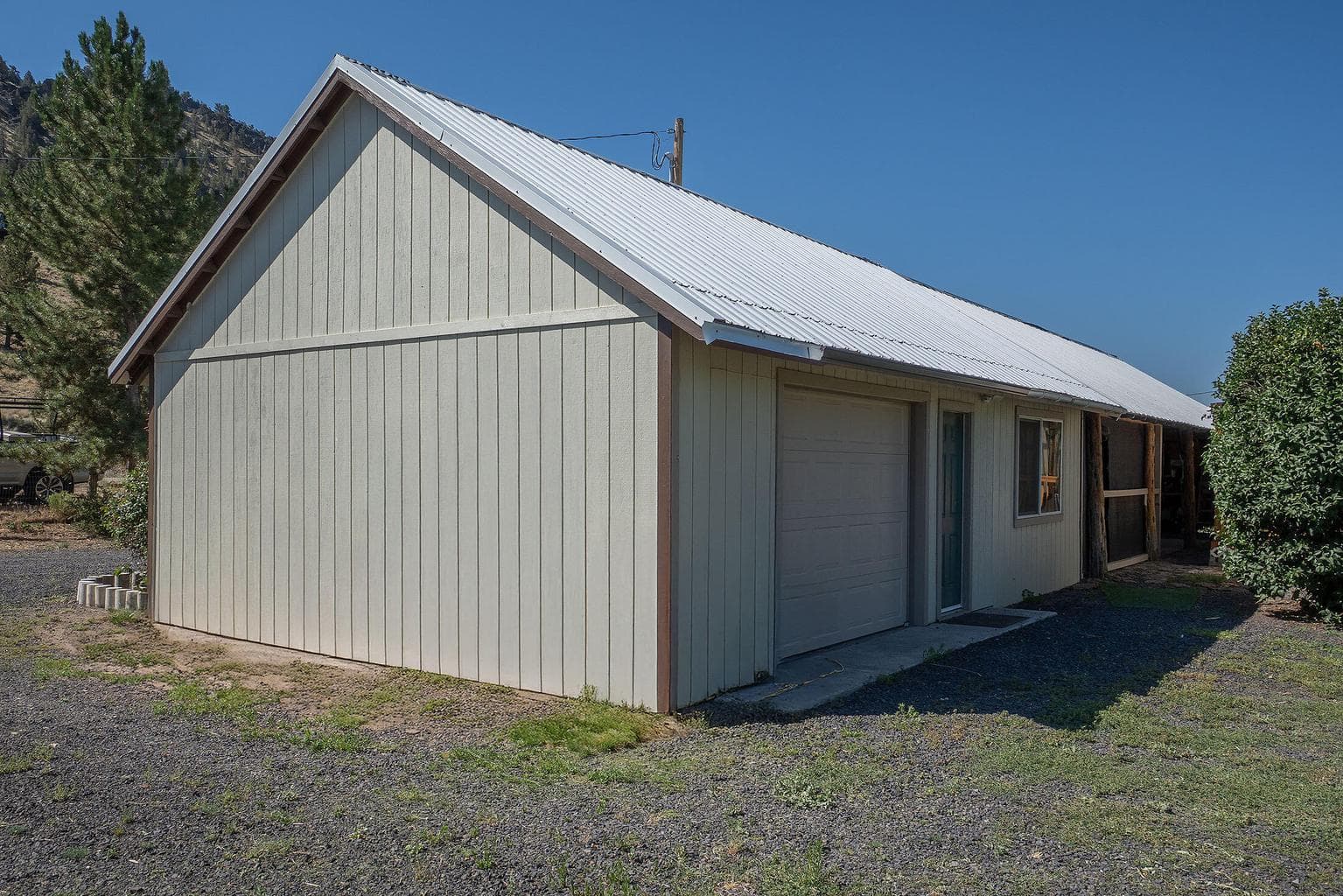 22'x80' building that features studio/guest room space, single car garage, carport, and screened in porch area