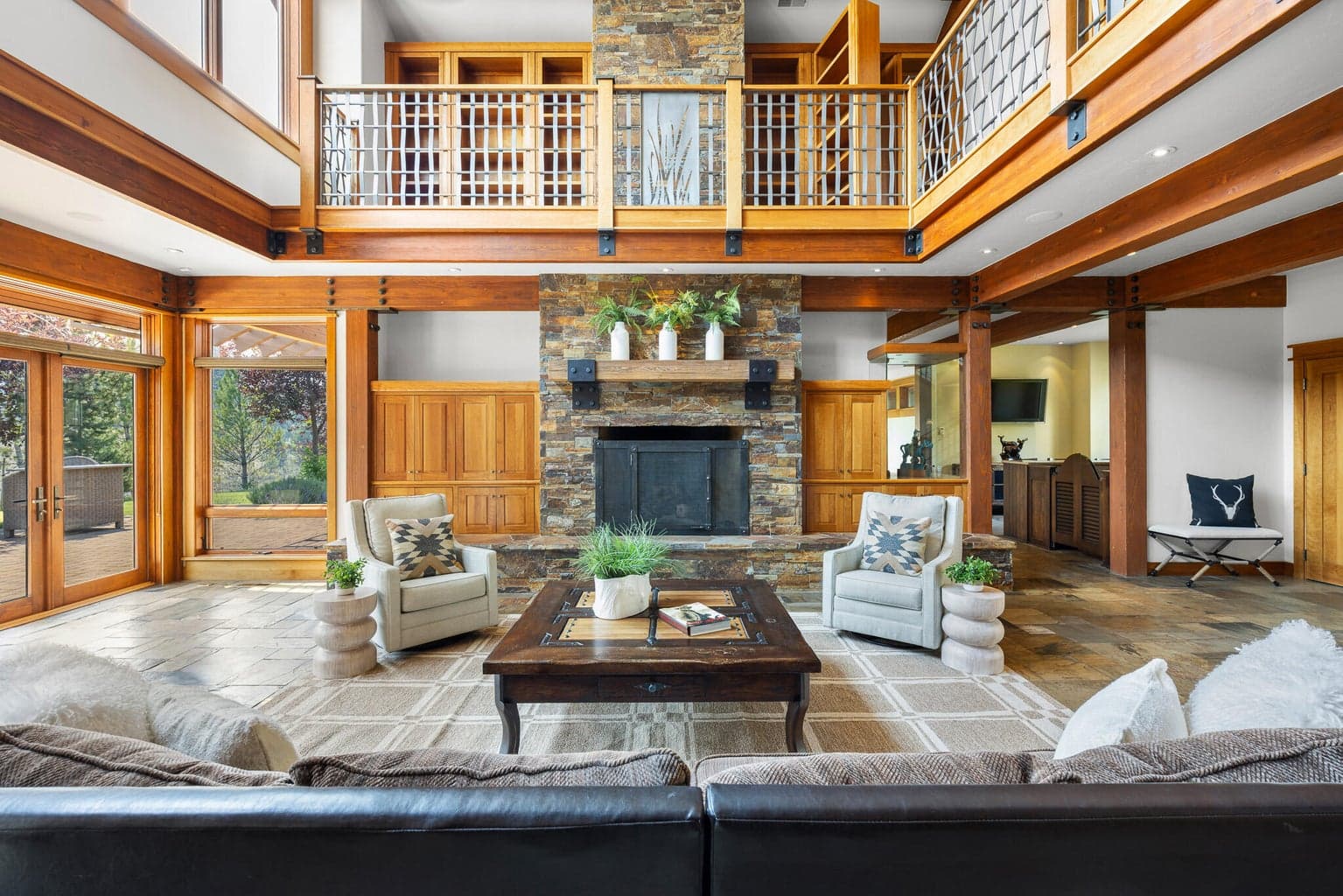 The heart of the home—soaring ceilings, rich cherry wood, and a statement stone fireplace create an atmosphere of mountain elegance.