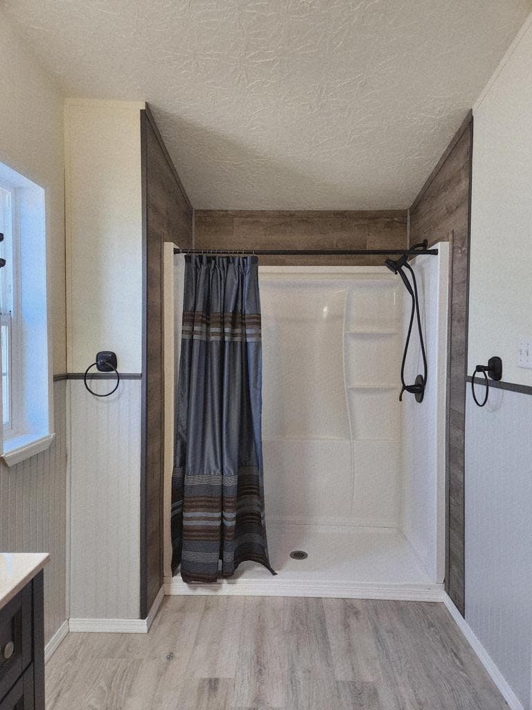 primary suite has large stall shower with tile surround.