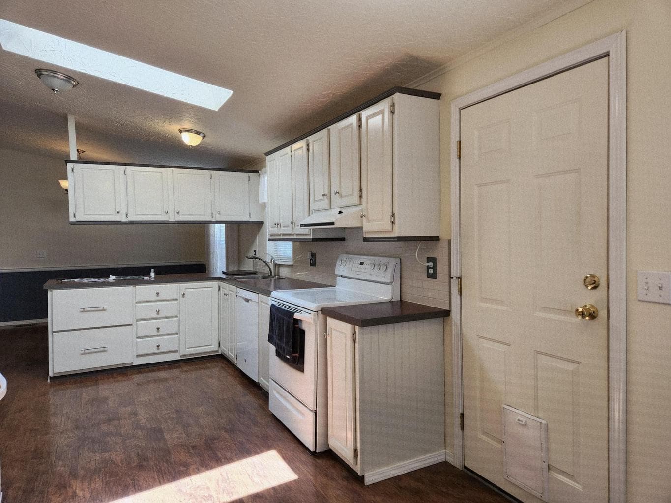 Backdoor leads to a covered deck and fenced backyard.