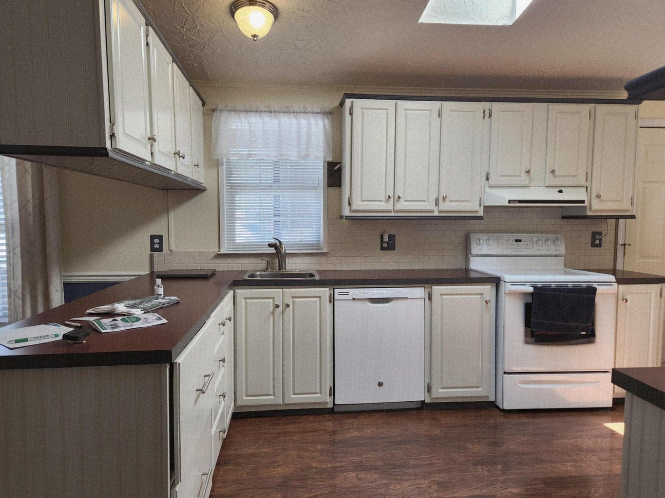 Kitchen is light and bright, has lots of cabinets and counterspace, laminate floors and skylight.