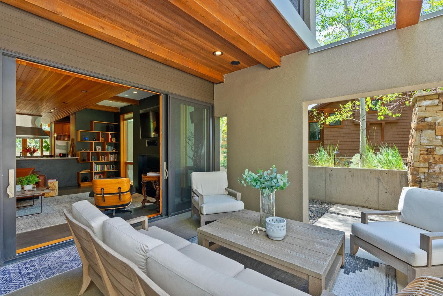 Outdoor living space with dramatic exposed beams and wood burn fireplace.