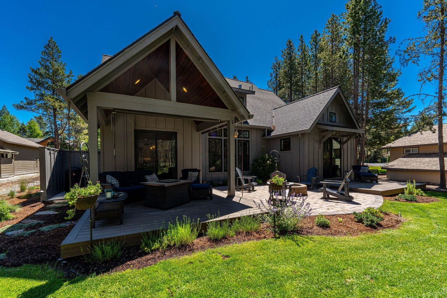 Covered porch, paver patio with gas firepit and extra decking by primary bedroom