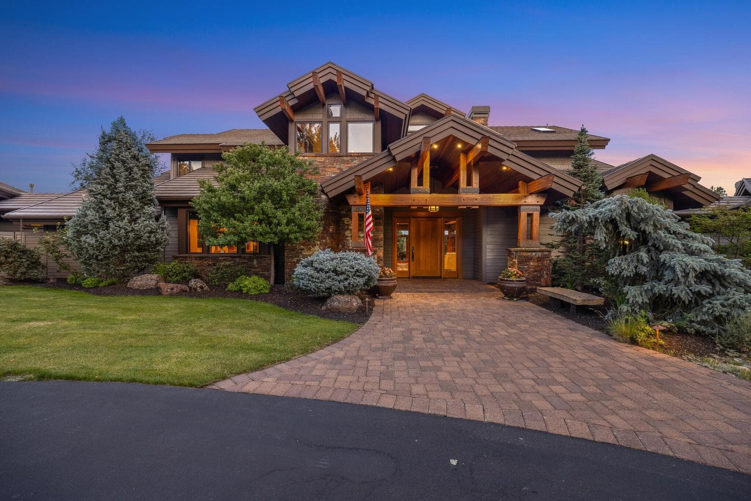 A grand first impression: custom Norman-built craftsmanship framed by mature pines and timeless Northwest design.