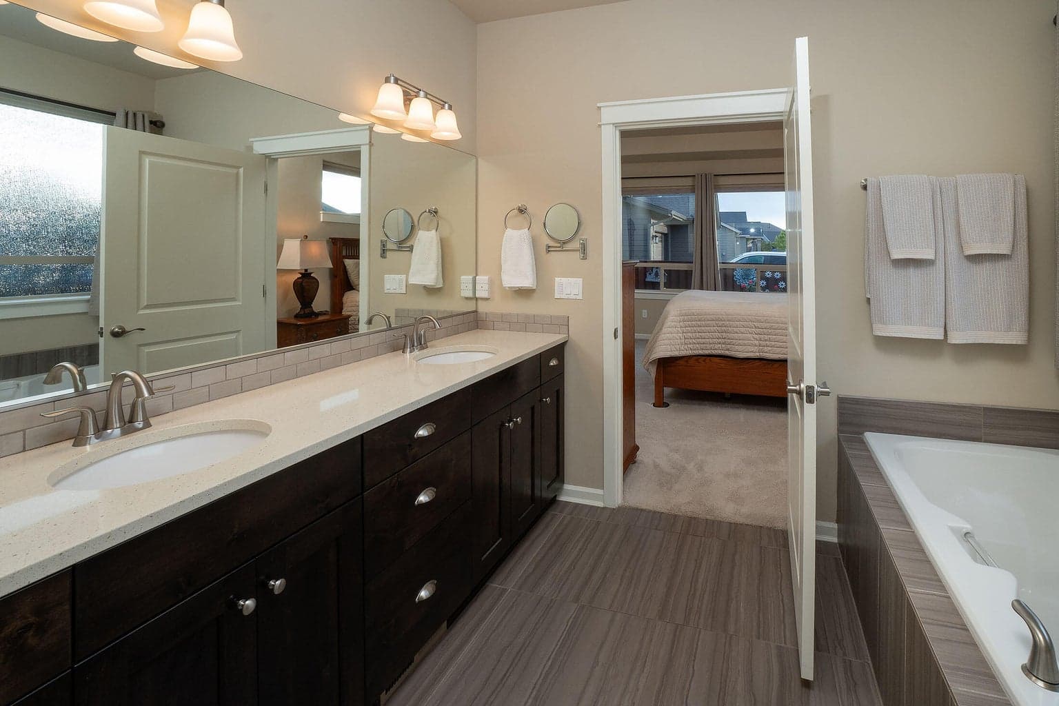 Primary suite bath with built-in soaking tub, tile surround and flooring, double vanity, water closet and large WIC.