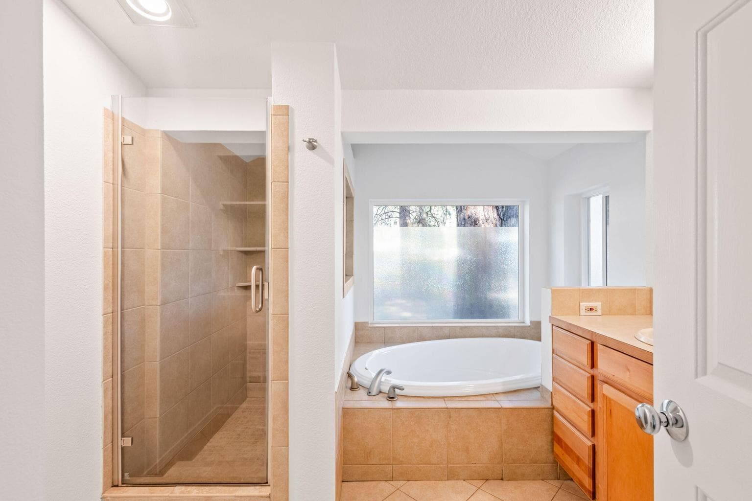 Walk-in tile shower and corner soaking tub.