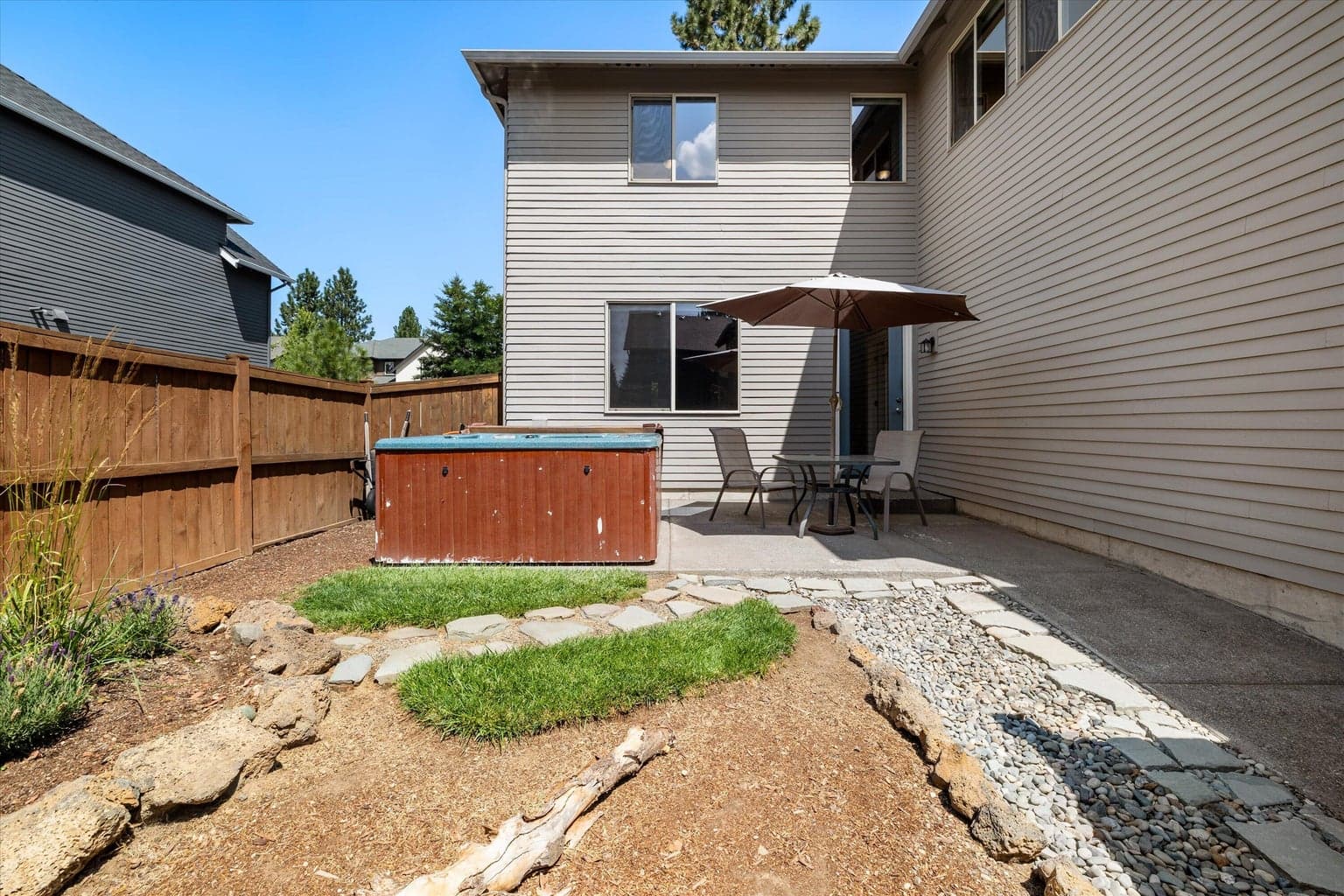 Easy to maintain yard. Relax in spa or enjoy the shade of umbrella with patio table.