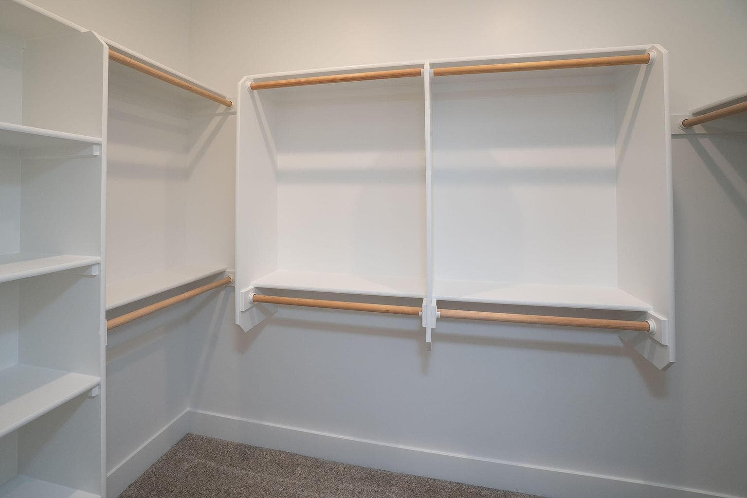 Walk in closet with solid shelving. All shelving in home of upgraded wood shelves