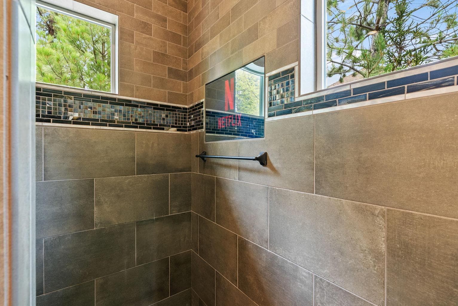 Main level Primary suite shower with mirror and integrated TV