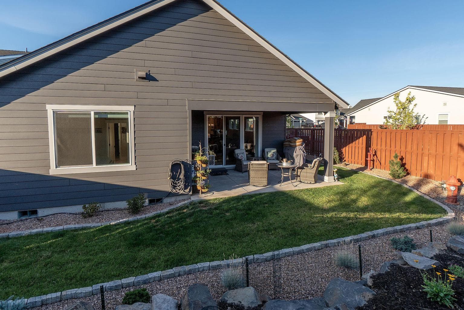 Private rear yard with large covered patio and beautiful landscaping