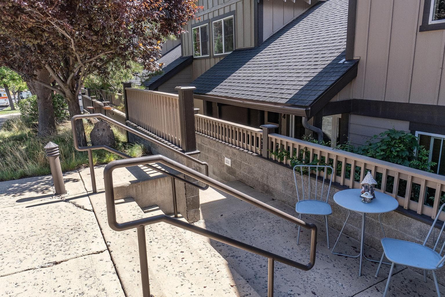 Front of the building, a short flight of stairs go down to the front door/patio.