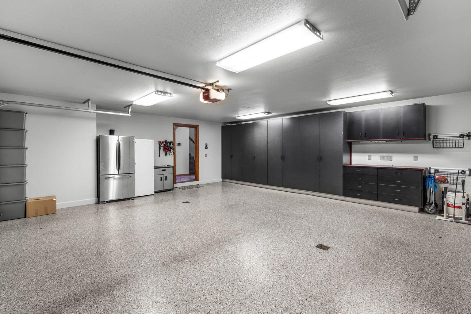Spacious 3-Car Garage with epoxy flooring and cabinetry
