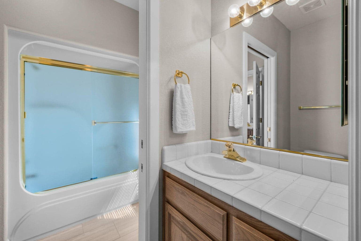 Jack & Jill bath provides private individual sinks and cabinet areas.
