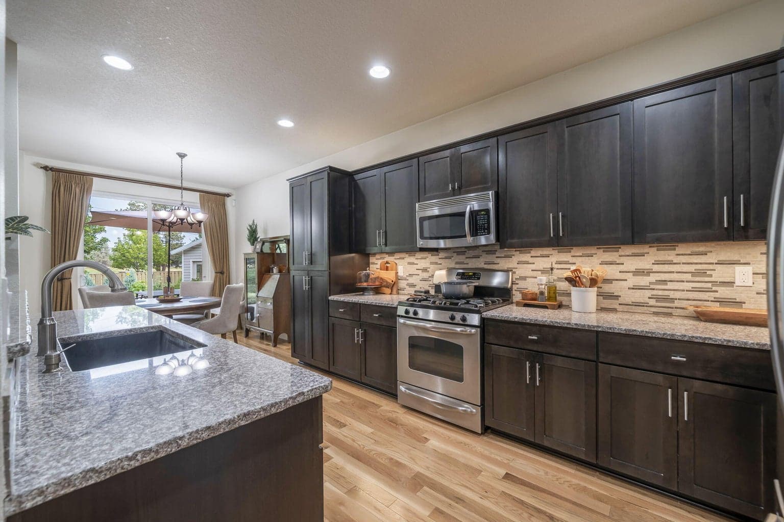 Slab granite countertops, under cabinet lighting, and included stainless steel appliances.