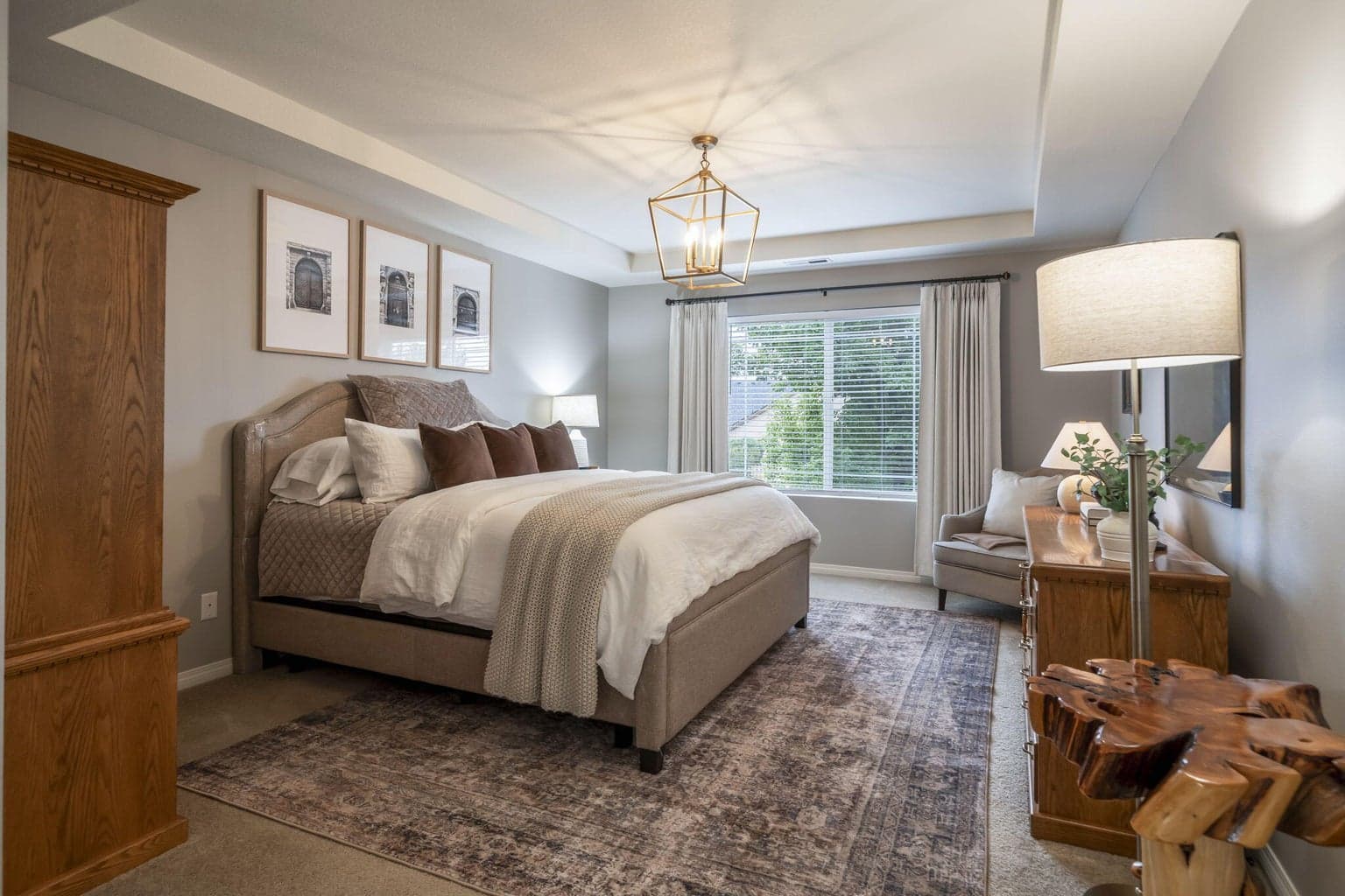 The spacious primary bedroom has a coffered ceiling with a chandelier.
