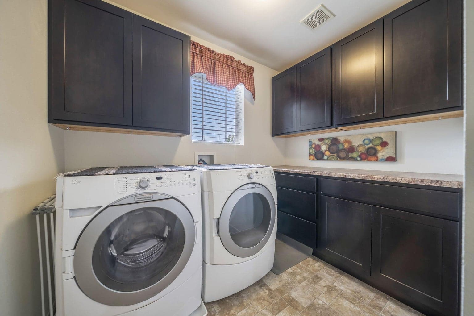 The upstairs laundry room has included washer and dryer, and upper and lower cabinetry for extra storage.