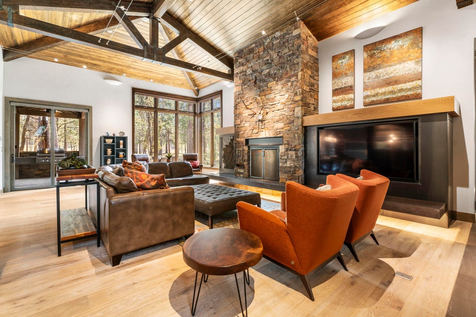 The expansive great room showcases a vaulted wood ceiling & full masonry wood-burning fireplace w/ convenient exterior wood box access.