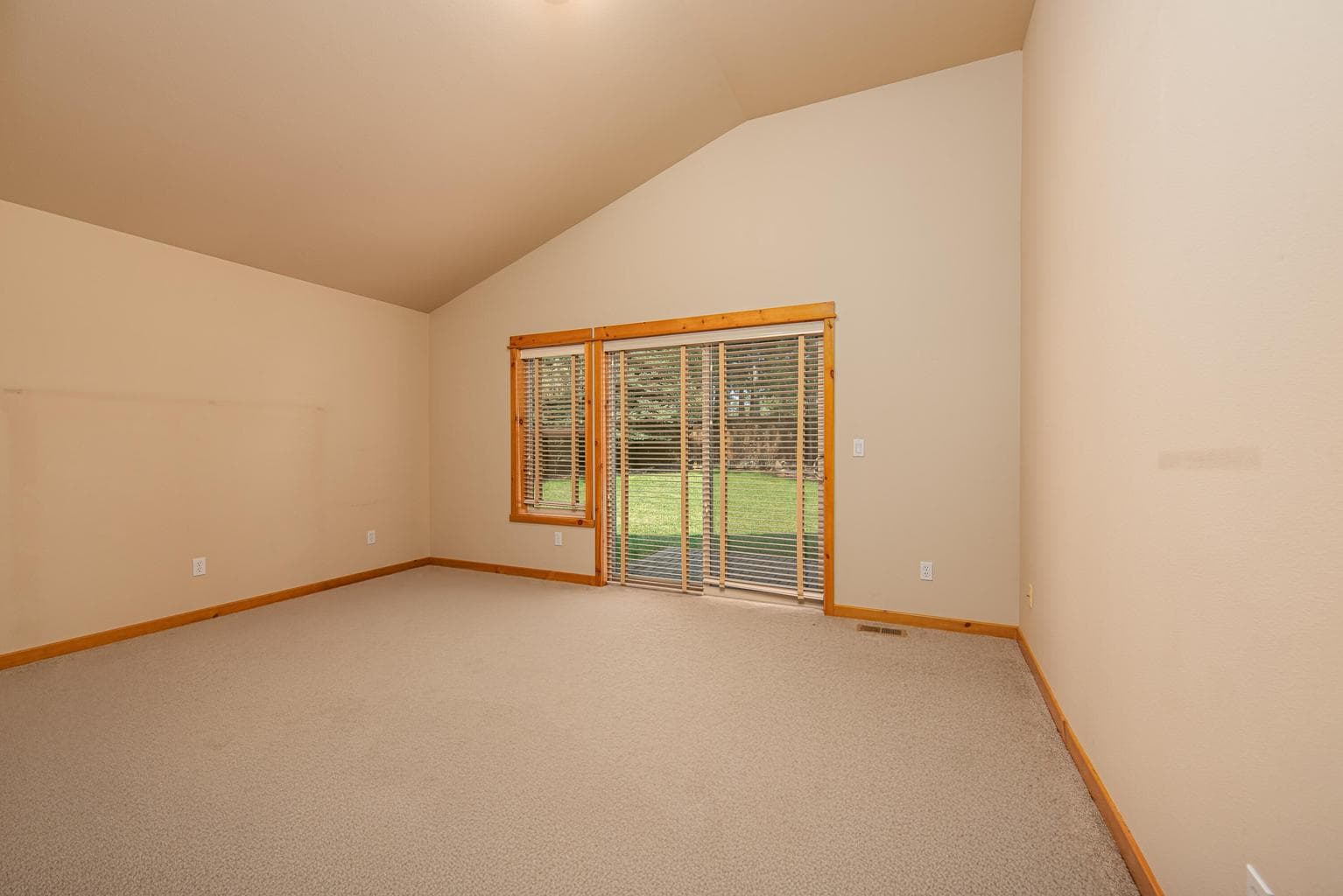 Primary bedroom with slider off of the lush backyard