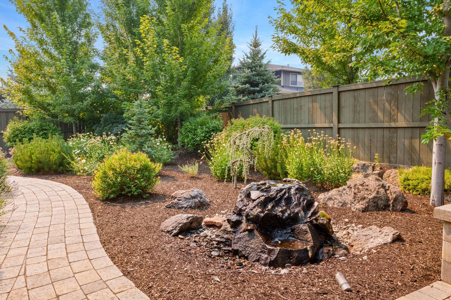 Backyard water feature adjacent to outdoor living space