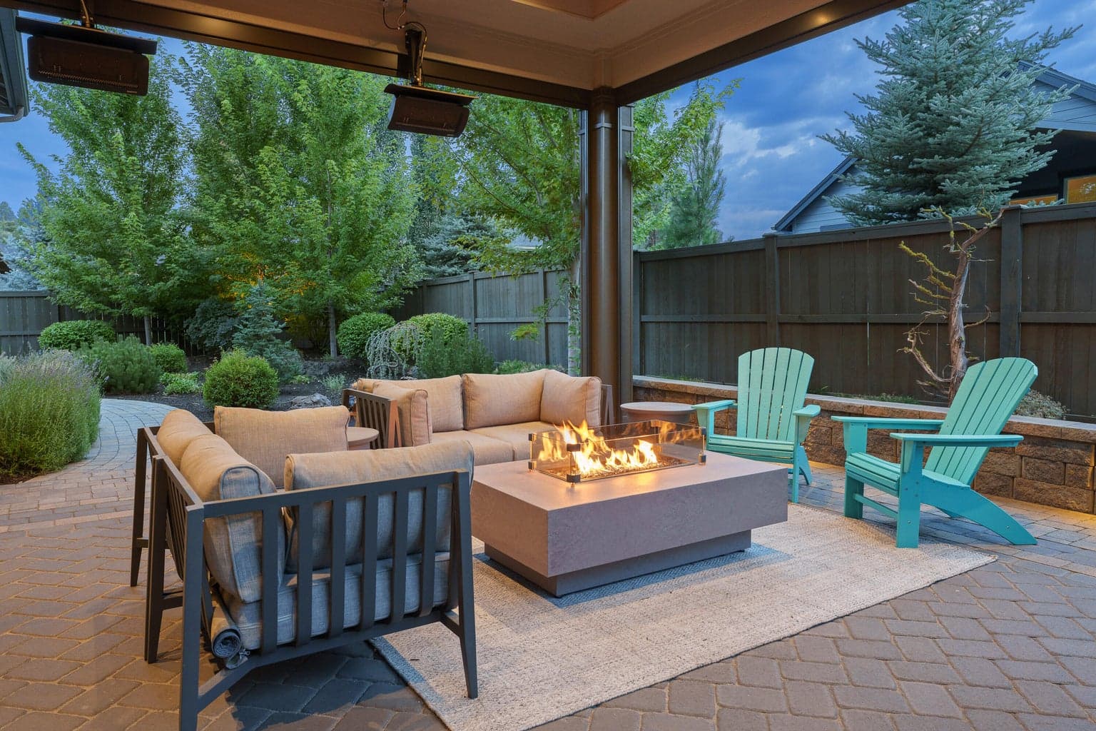 Four season outdoor living space with ceiling-mounted heaters and automated privacy screens