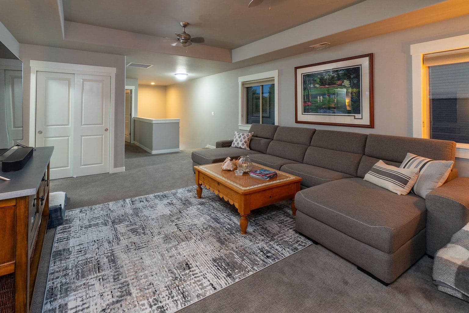 Loft living area with coffered ceiling and ceiling fans. View to the front of home.