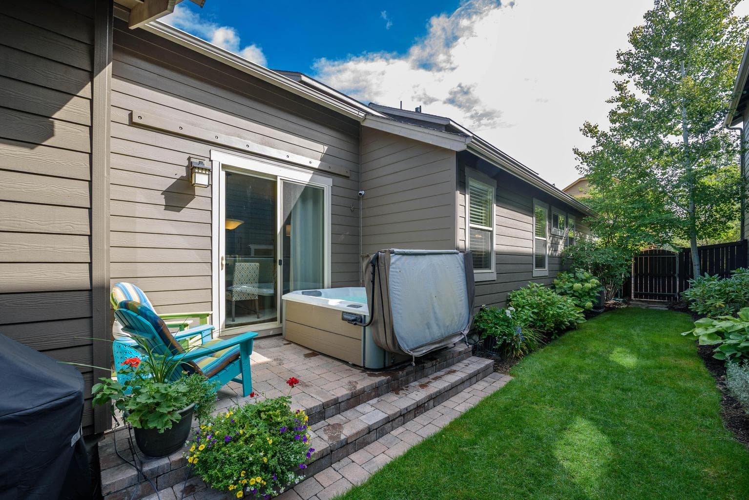 Beautiful lush yard with paver patio and inviting hot tub