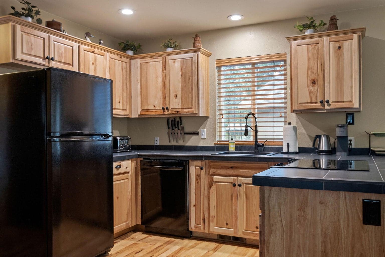 Updated kitchen with hickory cabinets and tiled counter tops.