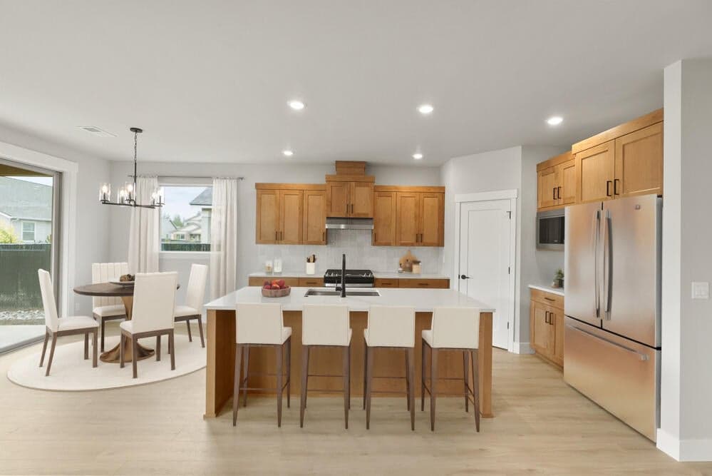 Kitchen with corner walk in pantry, quartz eating bar, and hood vent . This photo has been virtually staged.