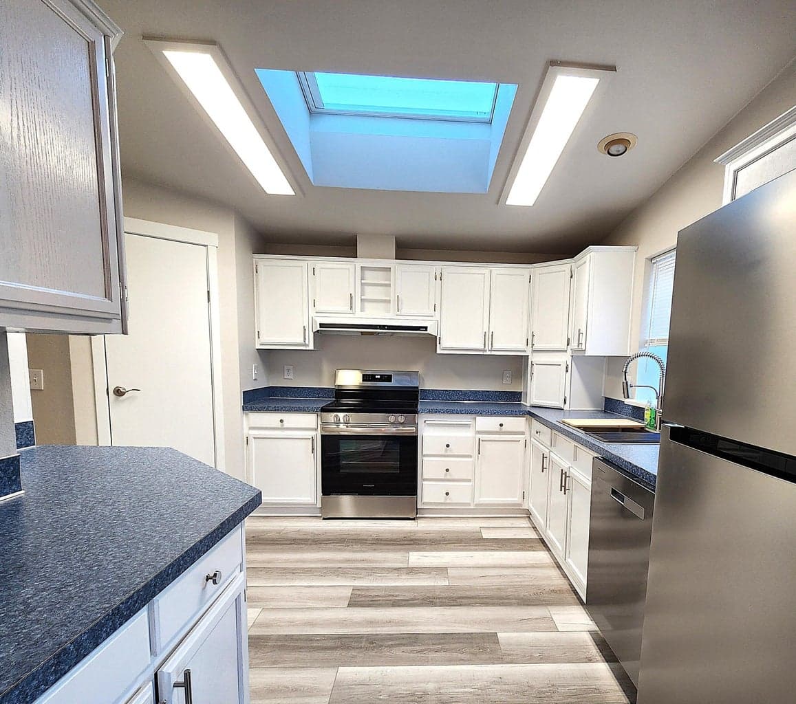 Kitchen entrance from breakfast nook. Kitchen has skylight with solar shade.