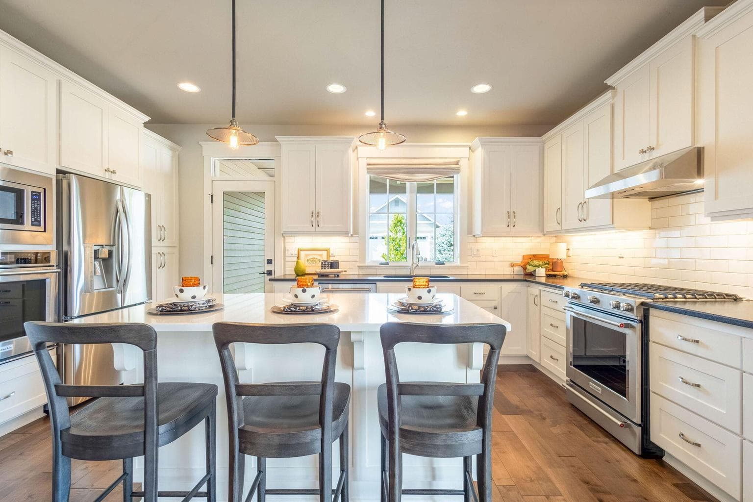 Chef’s kitchen with stainless appliances, double ovens, island seating & abundant cabinetry with pull-out drawers.