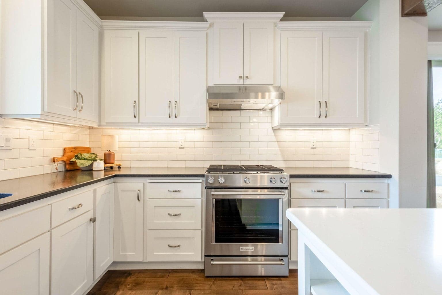 Chef’s kitchen with stainless appliances, double ovens, island seating & abundant cabinetry with pull-out drawers.