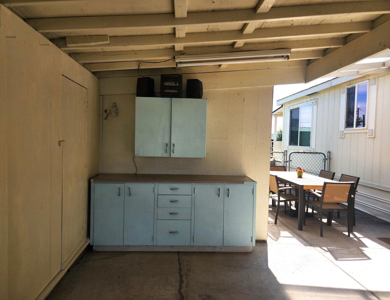 Storage and work area at the back of the carport. Attached shed behind cabinetry