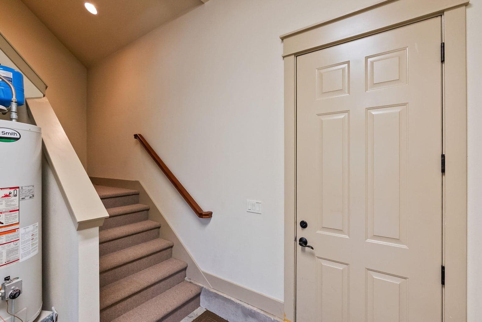 Man door to back yard and stairway to finished storage room