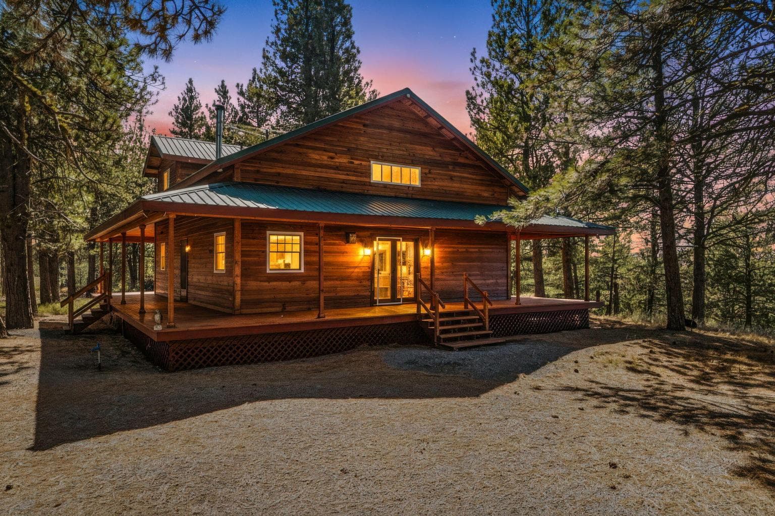 Atmospheric sunset shot of the lit-up log cabin.
