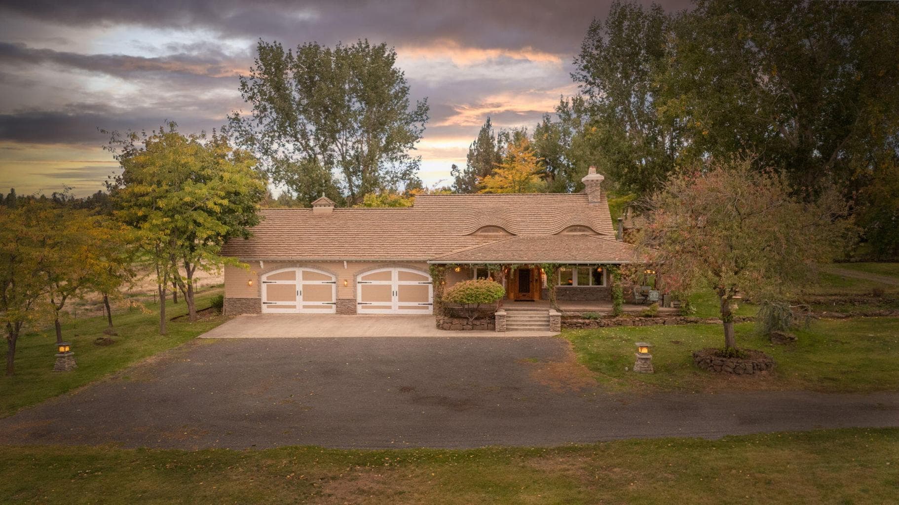 Front of the house at sunset w/4 car garage and mature trees