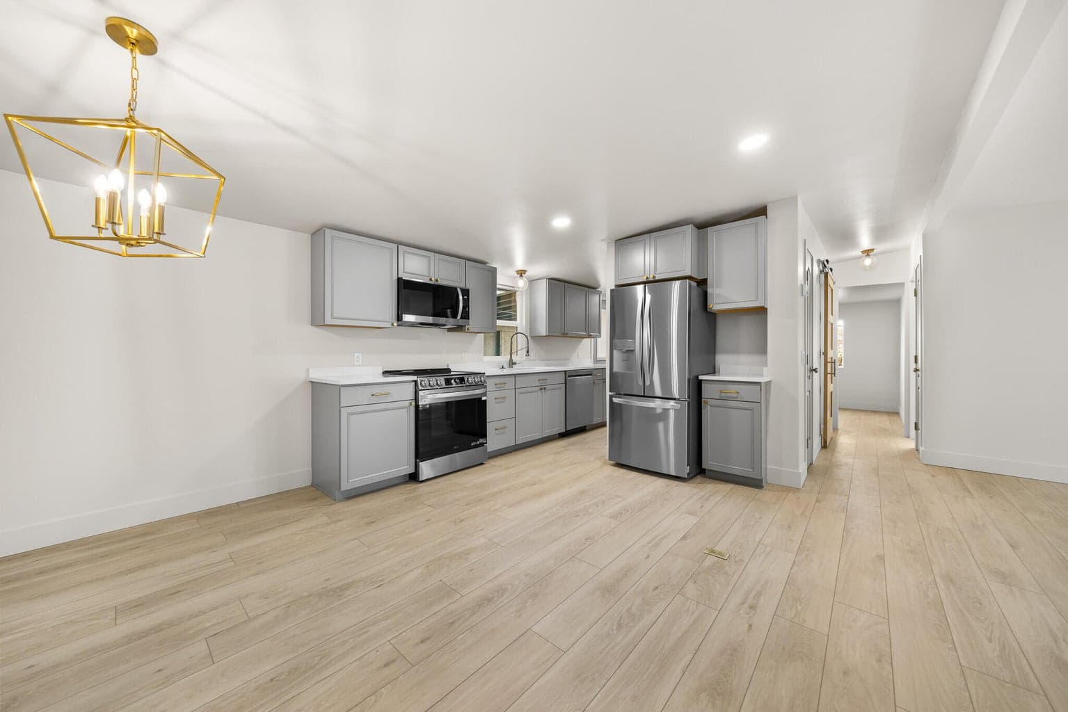 Kitchen and dining area are beautiful, kitchen has custom gray cabinetry, quartz counters and brass hardware.