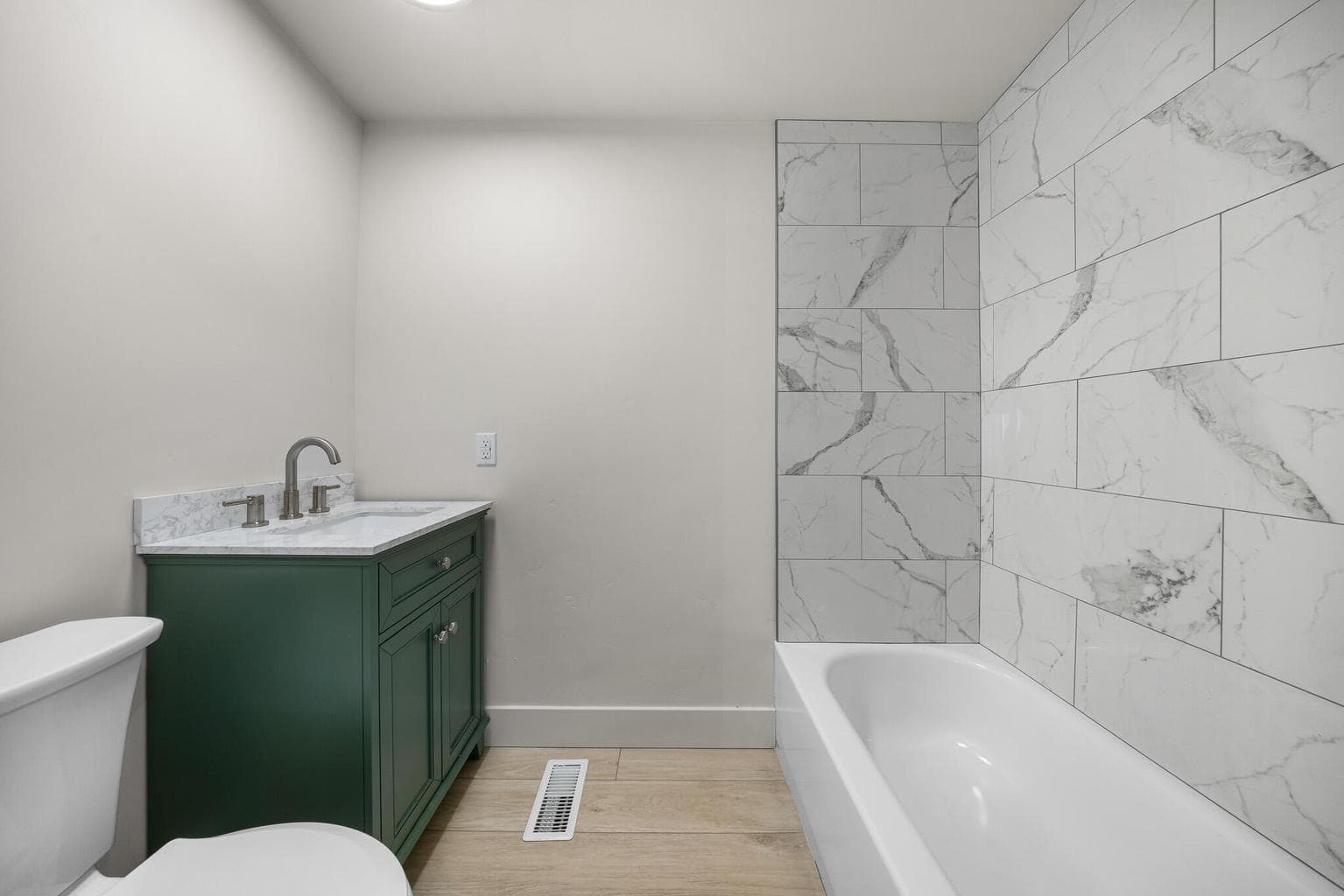 Guest bath is beautiful has a beautiful vanity and tiled shower and tub.