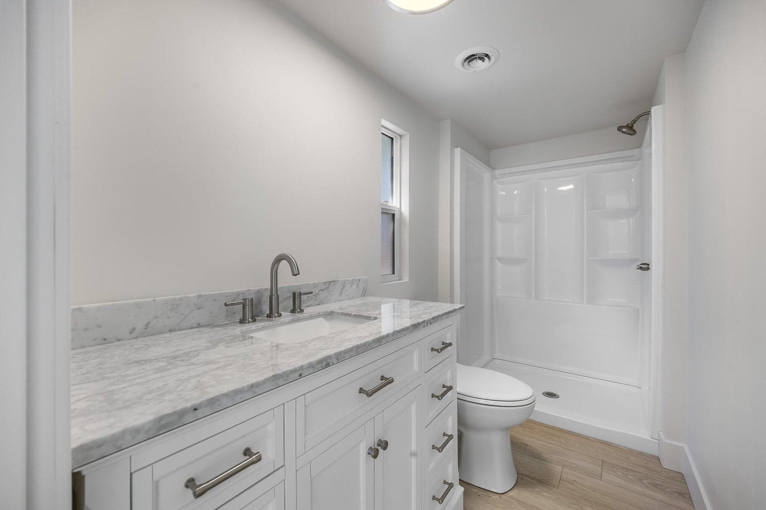 Primary suite has beautiful vanity and large stall shower.