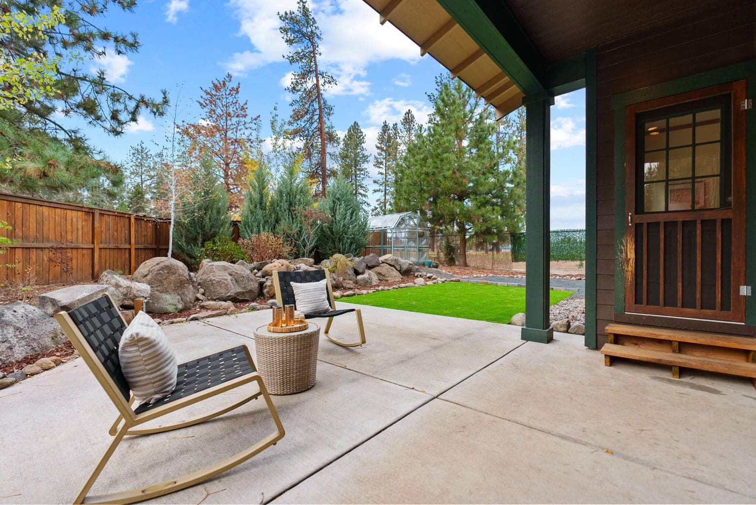 Perfect for outdoor living and hobbies is the fenced yard featuring the 180 SF shed, separate greenhouse, raised garden beds with a drip system, and a covered patio.