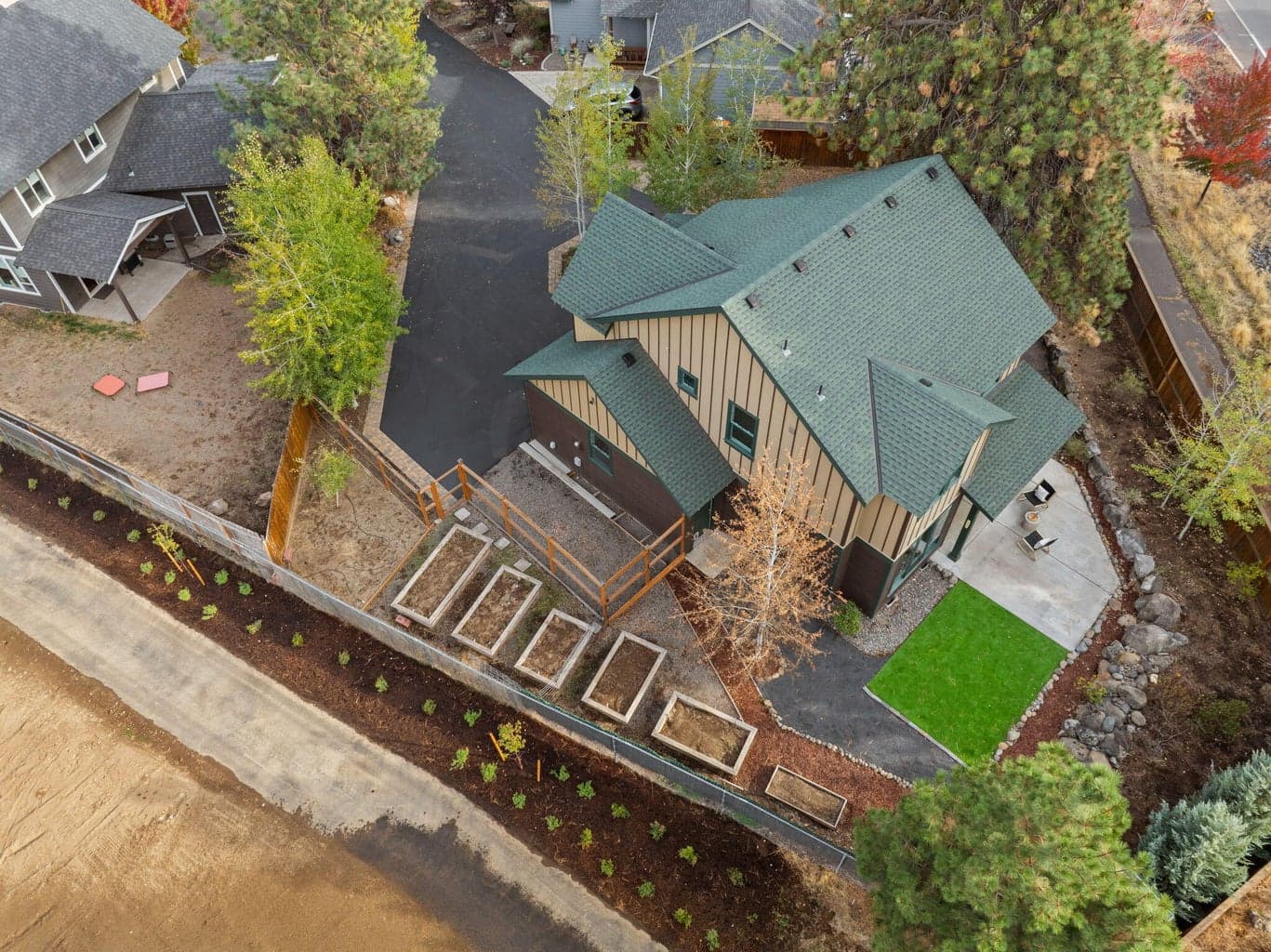 Perfect for outdoor living and hobbies is the fenced yard featuring the 180 SF shed, separate greenhouse, raised garden beds with a drip system, and a covered patio.
