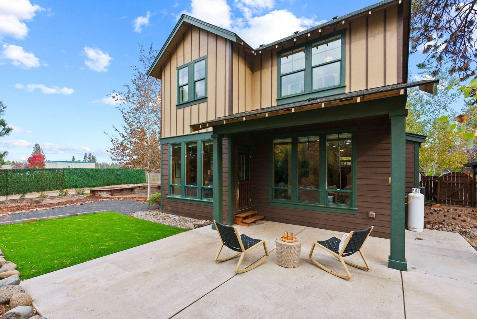 Perfect for outdoor living and hobbies is the fenced yard featuring the 180 SF shed, separate greenhouse, raised garden beds with a drip system, and a covered patio.