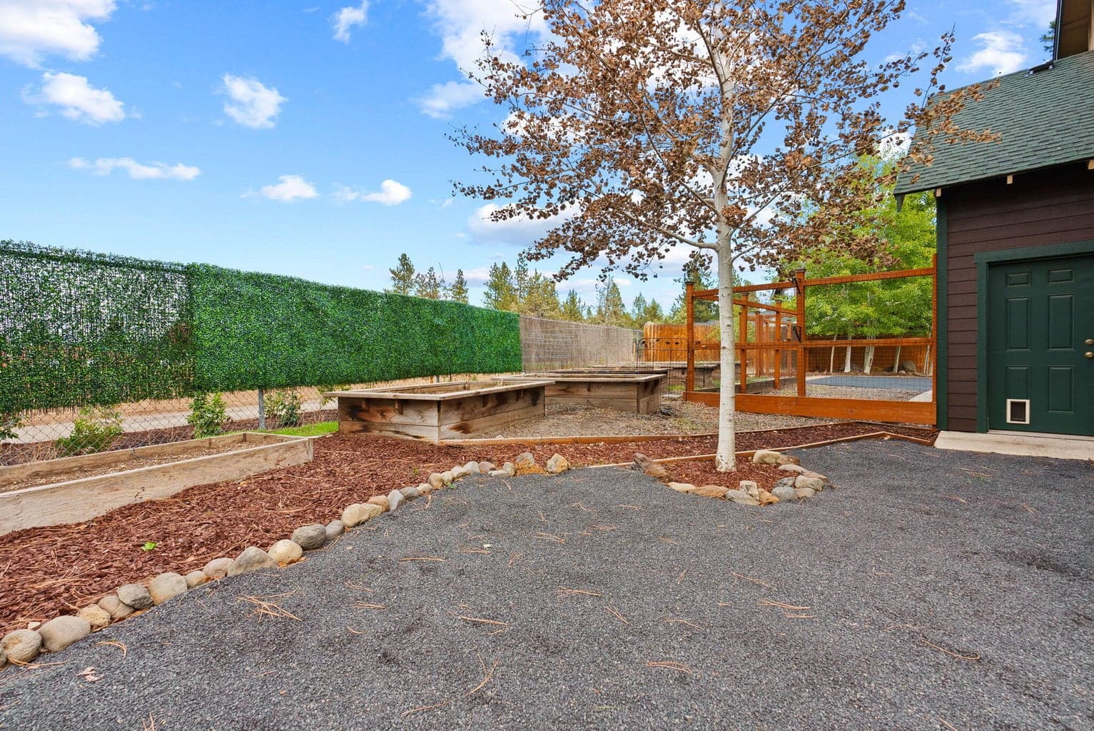 Perfect for outdoor living and hobbies is the fenced yard featuring the 180 SF shed, separate greenhouse, raised garden beds with a drip system, and a covered patio.
