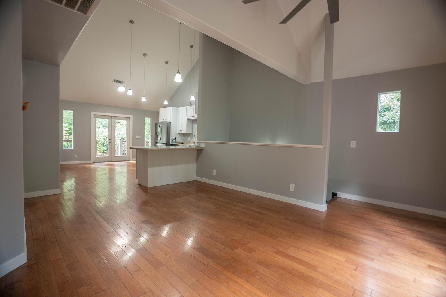 Spacious second-level living featuring vaulted ceilings, abundant natural light, and seamless access to the patio for effortless indoor-outdoor flow.
