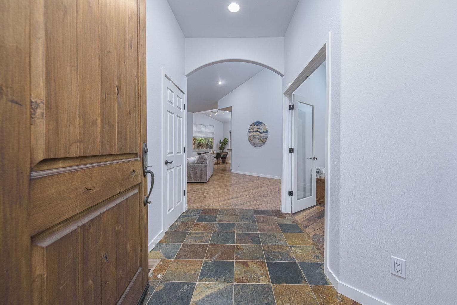 Slate entry with a coat closet on one side and double glass doors to the office on the other side