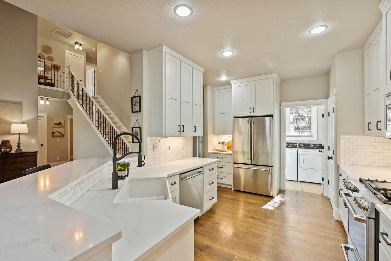Chef's kitchen with quartz slab countertops, farmhouse sink, pantry cupboard, under cabinet lighting, GE Cafe appliances, propane range, and more!