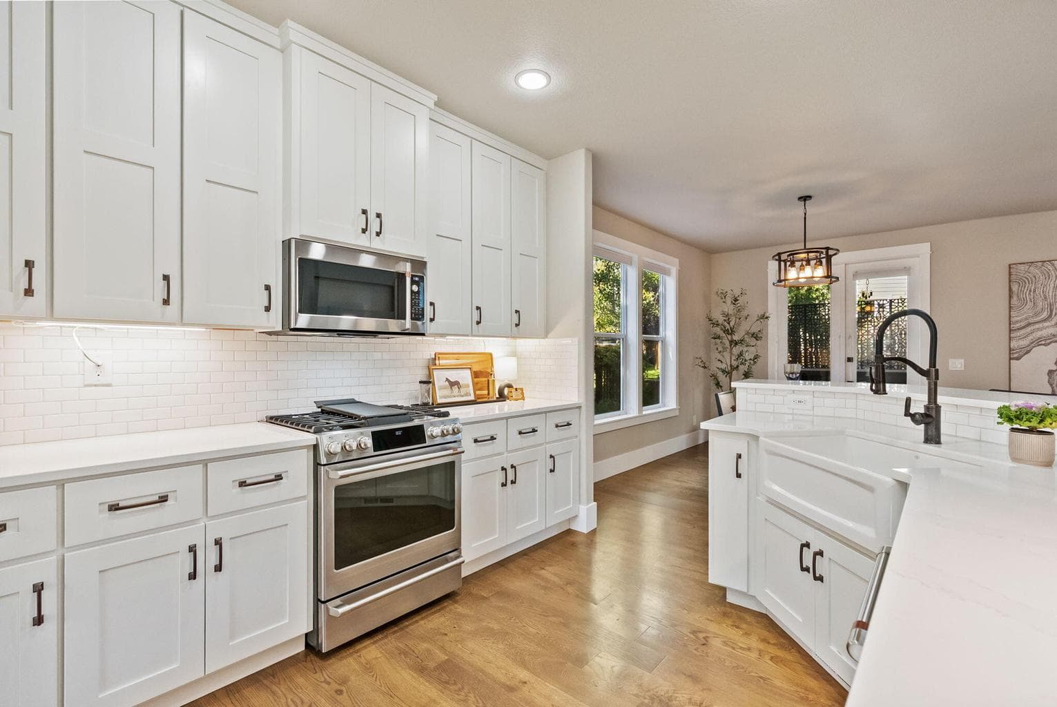Chef's kitchen with quartz slab countertops, farmhouse sink, pantry cupboard, under cabinet lighting, GE Cafe appliances, propane range, and more!