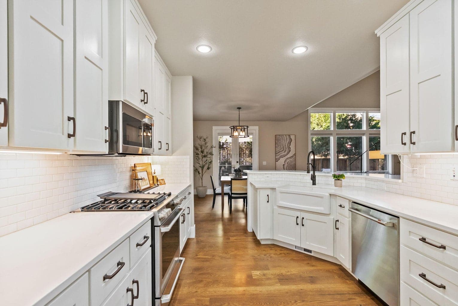 Chef's kitchen with quartz slab countertops, farmhouse sink, pantry cupboard, under cabinet lighting, GE Cafe appliances, propane range, and more!
